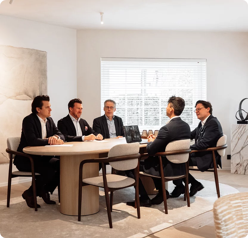 Vijf medewerkers van DaVinci overleggen al zittend rond een marmeren tafel