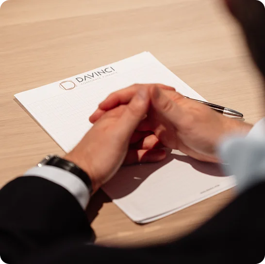 Notitieblok met het logo van DaVinci met daarop in elkaar gehaakte handen